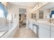 Bright bathroom featuring a double vanity, soaking tub, and access to the Primary bedroom at 9288 Valley Betica Ave, Las Vegas, NV 89148