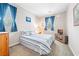 Comfortable bedroom features a full-sized bed, blue curtains, and a matching striped comforter, creating a relaxing retreat at 9288 Valley Betica Ave, Las Vegas, NV 89148