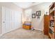 Neutral bedroom with a carpeted floor, a large closet, a small window with curtains, and a wooden storage bench at 9288 Valley Betica Ave, Las Vegas, NV 89148