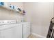 Functional laundry room with a washer, a dryer, and wire shelving for storage, offering convenience for everyday chores at 9288 Valley Betica Ave, Las Vegas, NV 89148