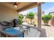 Relaxing covered patio area with stylish wicker seating, grill, and landscaped backyard at 9288 Valley Betica Ave, Las Vegas, NV 89148