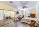This bedroom features mirrored closet doors, tiled floors, and a ceiling fan at 979 Coatbridge St, Las Vegas, NV 89145