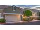 Charming townhome features a two-car garage, desert landscaping, and stone accents for added curb appeal at 979 Coatbridge St, Las Vegas, NV 89145