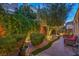 Back patio featuring ambient lighting, lush landscaping, and seating area at 979 Coatbridge St, Las Vegas, NV 89145