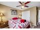 Well-lit bedroom featuring wood floors, ceiling fan, and patterned quilt at 1068 African Eagle Ave, Henderson, NV 89015