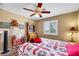 Bright bedroom features a ceiling fan, wood-look flooring, window with natural light, and bedside lamps at 1068 African Eagle Ave, Henderson, NV 89015
