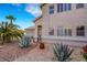 Exterior home view with desert landscaping, rock mulch, agave plants, and trees at 1068 African Eagle Ave, Henderson, NV 89015