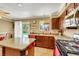 Bright kitchen featuring island, backyard access to pool, tile flooring, and dark cabinets at 1068 African Eagle Ave, Henderson, NV 89015