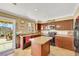 Well-lit kitchen features an island with bar seating, dark cabinets, and backyard access at 1068 African Eagle Ave, Henderson, NV 89015
