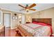 Cozy primary bedroom with hardwood floors, ceiling fan, a large bed, and access to bath at 1068 African Eagle Ave, Henderson, NV 89015