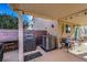 Covered patio area featuring a grill, outdoor seating, and a view of the backyard and landscaping at 1068 African Eagle Ave, Henderson, NV 89015