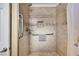 Modern tiled shower with shower head, safety bars and a built-in shelf for toiletries at 1068 African Eagle Ave, Henderson, NV 89015