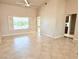 Living room featuring tile flooring, a ceiling fan, plantation shutters, and a doorway to another room at 10921 Grand Haven Ave, Las Vegas, NV 89134
