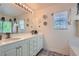Bathroom featuring double sinks with a large mirror and a vanity with white cabinets at 11074 Caramel Crest Ct, Las Vegas, NV 89135