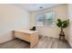 Minimalist office space with a large desk, light wood floors, and bright natural light at 11074 Caramel Crest Ct, Las Vegas, NV 89135