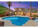 Stunning backyard features a pristine pool, rock waterfall, and lush landscaping, perfect for outdoor relaxation at 11649 Royal Derwent Dr, Las Vegas, NV 89138