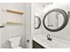 Updated bathroom featuring modern floating shelves, a round mirror, and new fixtures at 11649 Royal Derwent Dr, Las Vegas, NV 89138