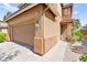 Close-up of the home's facade featuring a two-car garage and drought-tolerant landscaping at 11649 Royal Derwent Dr, Las Vegas, NV 89138