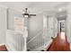 Upstairs hallway with wooden floors and white banister overlooking the stairway at 11649 Royal Derwent Dr, Las Vegas, NV 89138