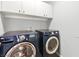 Laundry room with front loading washer, dryer, and white storage cabinets at 11649 Royal Derwent Dr, Las Vegas, NV 89138