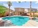 Inviting backyard pool and spa featuring lush landscaping, a covered patio, and a serene outdoor living space at 11649 Royal Derwent Dr, Las Vegas, NV 89138