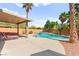 Private backyard pool with a covered patio featuring lush landscaping and mature trees at 11649 Royal Derwent Dr, Las Vegas, NV 89138
