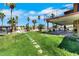Lush backyard with a covered patio, green lawn, and direct access to the pool at 1385 Morning Sun Way, Las Vegas, NV 89110