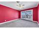A bedroom with red walls, and sliding glass doors to the backyard at 1385 Morning Sun Way, Las Vegas, NV 89110