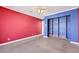 Bedroom with red and blue walls, built in bookcase, and neutral carpet at 1385 Morning Sun Way, Las Vegas, NV 89110