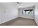 A bedroom with a window view of palm trees, neutral paint and carpet at 1385 Morning Sun Way, Las Vegas, NV 89110