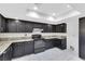Charming kitchen featuring dark cabinetry, granite countertops, and stainless steel appliances at 1385 Morning Sun Way, Las Vegas, NV 89110