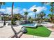 Stunning pool area with artificial turf, rock features, and mature palms create an outdoor retreat at 1385 Morning Sun Way, Las Vegas, NV 89110