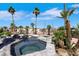 Backyard swimming pool with palm trees and rock features, providing a tropical oasis at 1385 Morning Sun Way, Las Vegas, NV 89110
