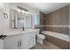Bright bathroom featuring a tub, modern fixtures, and white cabinetry with a large, sleek mirror at 1511 Irene Dr, Boulder City, NV 89005