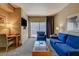 The living room features a desk, a sofa, a chair, a TV, and access to the balcony at 211 E Flamingo Rd # 615, Las Vegas, NV 89169