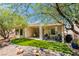 Beautiful backyard featuring artificial grass, a covered patio, and mature trees providing shade at 2111 Tiger Links Dr, Henderson, NV 89012