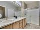 Bathroom featuring double sinks, a glass shower door, and tile flooring at 2111 Tiger Links Dr, Henderson, NV 89012