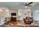 Cozy living room with hardwood floors, ceiling fan and open access to the adjacent dining area at 2111 Tiger Links Dr, Henderson, NV 89012