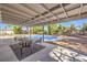 Relax under the covered patio with comfortable seating, overlooking the inviting in-ground pool and backyard at 2504 La Solana Way, Las Vegas, NV 89102