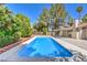 Relaxing backyard with an inviting rectangular pool, lush greenery, and a covered patio area, ideal for outdoor enjoyment at 2504 La Solana Way, Las Vegas, NV 89102