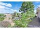 Inviting backyard patio with a view, mature trees, desert landscaping, and metal fence at 2504 Libretto Ave, Henderson, NV 89052