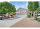 Well-maintained home featuring a two-car garage, mature trees, and desert landscaping at 2504 Libretto Ave, Henderson, NV 89052