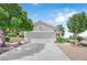 Beautiful home featuring a two-car garage, mature trees, and desert landscaping at 2504 Libretto Ave, Henderson, NV 89052