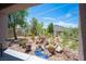 Charming backyard with desert landscaping, featuring cacti, rocks, and a decorative blue stream at 2545 Divine Sky Dr, Henderson, NV 89044