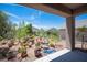 View of the backyard with desert-themed landscaping, including cacti, rocks, and a decorative water feature at 2545 Divine Sky Dr, Henderson, NV 89044
