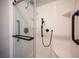 Modern bathroom shower with sleek white tile, black fixtures, and convenient grab bars at 2545 Divine Sky Dr, Henderson, NV 89044