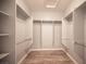 Walk-in closet with custom shelving, hanging racks, and wood-look floors at 2545 Divine Sky Dr, Henderson, NV 89044