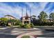 Community clubhouse featuring well-manicured landscaping, flags, and circular driveway at 2545 Divine Sky Dr, Henderson, NV 89044