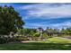 Beautifully landscaped community entrance featuring lush greenery, trees, and manicured lawns at 2545 Divine Sky Dr, Henderson, NV 89044