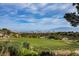 Scenic view of a golf course and the city skyline in the distance, featuring green grass at 2545 Divine Sky Dr, Henderson, NV 89044